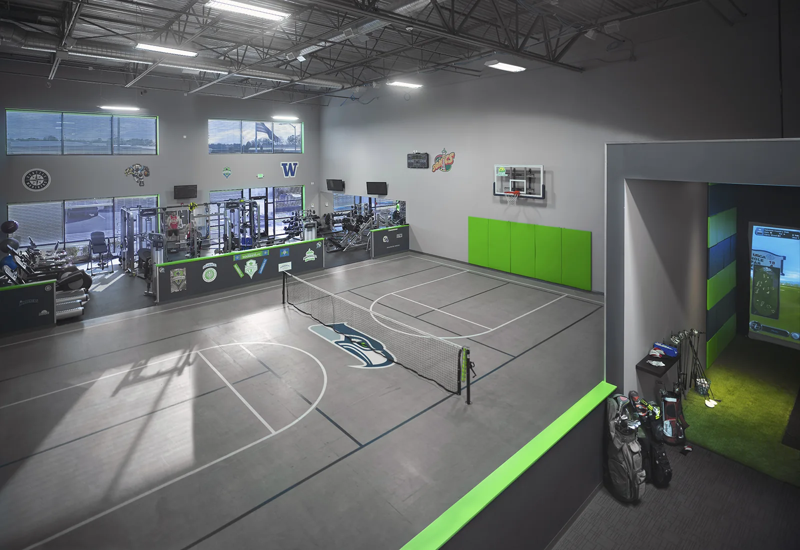 Spacious indoor athletic facility featuring a multi-sport court, fitness gym, and a golf simulator room.