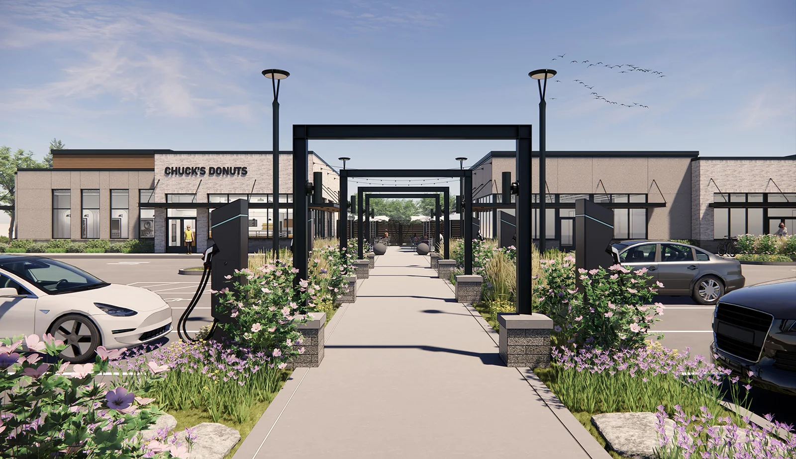 Rendering of a modern retail plaza with a central pedestrian walkway, black metal arches, and EV charging stations.